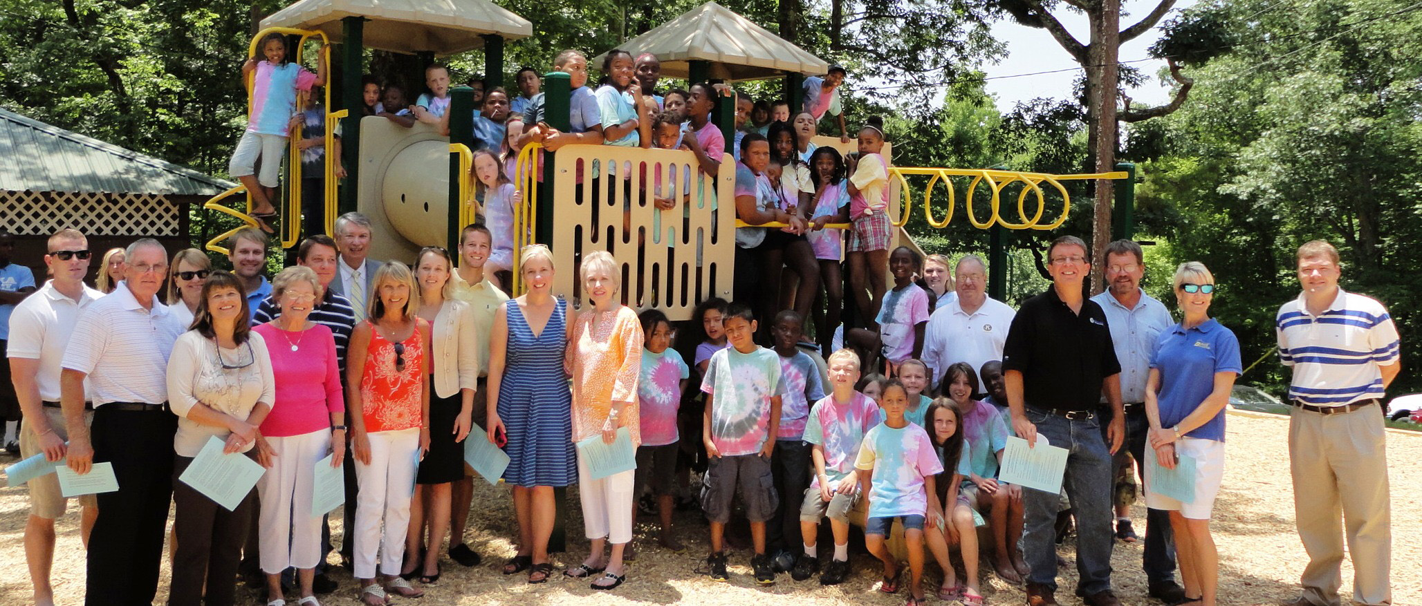 Image of the Kiwanis club with Kamp Kiwanis children enjoying a playground