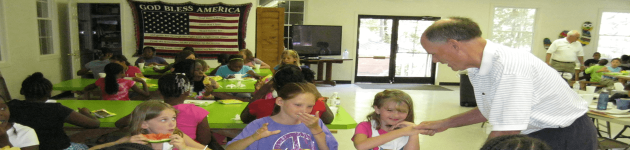 Image of the Kiwanis club with Kamp Kiwanis children enjoying a playground
